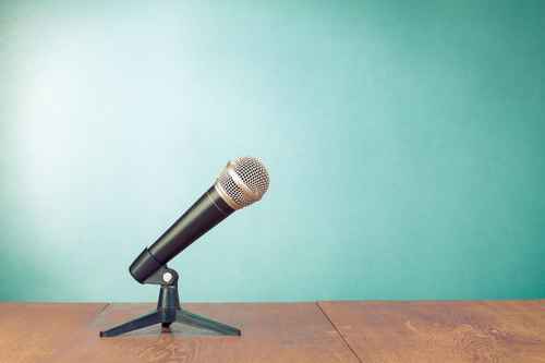 Classic microphone on table front aquamarine wall background
